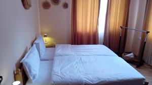 a bed with white sheets and pillows in a bedroom at Holiday guest house KEMO in Sapareva Banya +62 photos