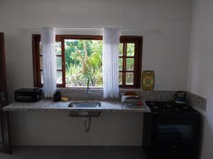 a kitchen counter with a sink and a window at Casa da matta in Ubatuba