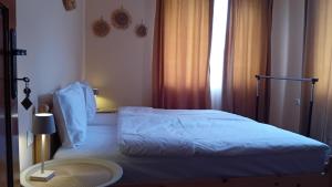 a bedroom with a white bed with a window at Holiday guest house KEMO in Sapareva Banya