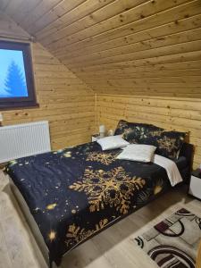 a bedroom with a bed in a wooden room at Cabana La Aurel in Subcetate