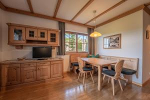 a kitchen with a wooden table and a dining room at Residence Burghof in Siusi