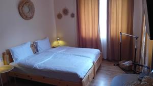 a bedroom with a large bed with white sheets at Holiday guest house KEMO in Sapareva Banya