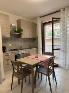 a kitchen with a table and chairs and a table and a window at Via Veneto in Loreto Aprutino
