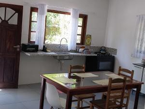 a kitchen with a table and chairs and a sink at Casa da matta in Ubatuba +9 photos