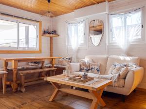 a living room with a couch and a table at L'authentique chalet en bois sur pilotis in Gruissan