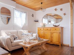 a living room with a couch and a table at L'authentique chalet en bois sur pilotis in Gruissan