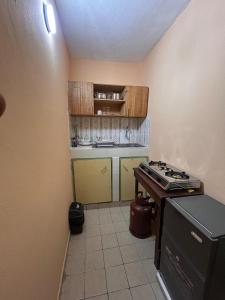 a small kitchen with a stove and a counter at Studio meublé Aéroport cité SIPIM in Abidjan