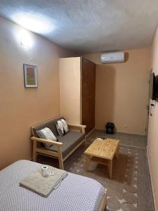 a room with a bed and a couch and a table at Studio meublé Aéroport cité SIPIM in Abidjan