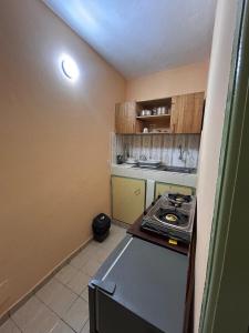 a small kitchen with a stove in a room at Studio meublé Aéroport cité SIPIM in Abidjan