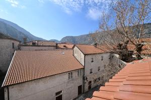 an overhead view of buildings with mountains in the background at Old town central in Kotor