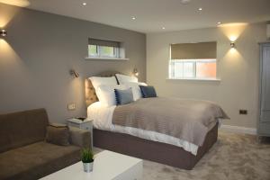 a bedroom with a large bed and a couch at Frinton Escapes in Frinton-on-Sea +9 photos