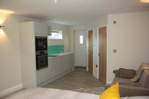 a living room with a couch and a kitchen at Frinton Escapes in Frinton-on-Sea