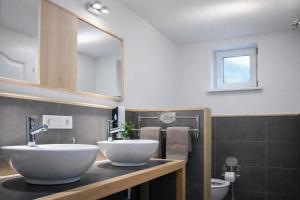 a bathroom with two sinks and a mirror at Valentina Lodge in Durbuy +24 photos