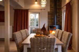 a dining room with a table with chairs and a fireplace at Valentina Lodge in Durbuy