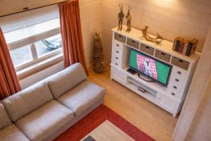 a living room with a couch and a tv at Valentina Lodge in Durbuy