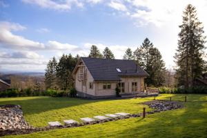 a small house on a hill with a green yard at Valentina Lodge in Durbuy