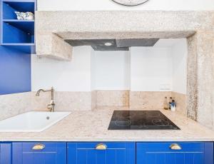 a kitchen with blue cabinets and a sink at Villas de Cintra in Sintra +224 photos