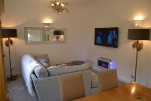 a living room with a couch and a tv at Frinton Escapes - The Cottage in Frinton-on-Sea +21 photos