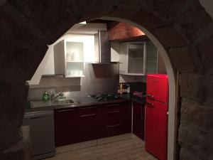 La cuisine est équipée d'un réfrigérateur rouge et d'un évier. dans l'établissement Gîte Elisa et Léna, à Riquewihr
