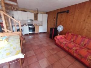 a living room with a couch and a kitchen at Holiday home Désirée in Sorico