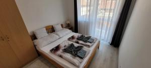 a small bedroom with two beds with blankets and pillows at Arany-Lak Hajdúszoboszló in Hajdúszoboszló