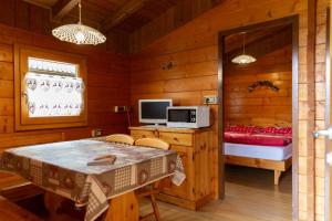 a room with a table and a bed and a television at Camping Val di Sole in Peio