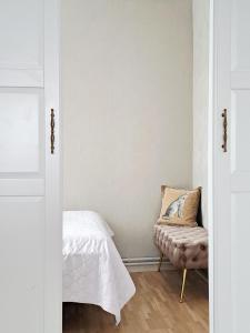 a bedroom with a bed and a chair at White Home & Garden in Klaipėda