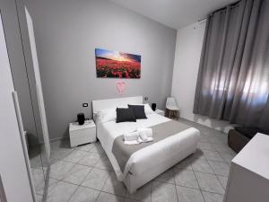 a white bedroom with a white bed and a couch at NoveQuattro Apartment in Cagliari