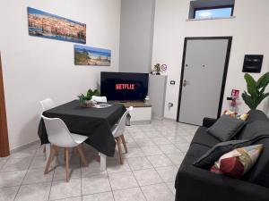 a living room with a table and a tv at NoveQuattro Apartment in Cagliari +8 photos