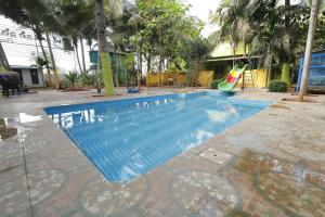 a swimming pool with a slide in a resort at Sri Kalki Jamjam Resort in Erode