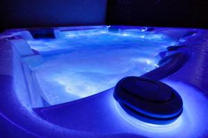 a blue bath tub with a black object in it at Domek A - domki w górach z prywatnym SPA - 4 seasons lodges Ustroń in Ustroń