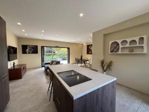 a kitchen and living room with a sink and a couch at Villa les pins in Chambonas