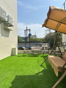a patio with a table and chairs and an umbrella at V Club in Bhuj