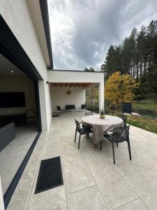 a patio with a table and chairs and a television at Villa les pins in Chambonas