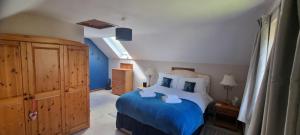 a bedroom with a blue and white bed and a window at Priory Stream, Lower Priory, Pembrokeshire in Milford Haven