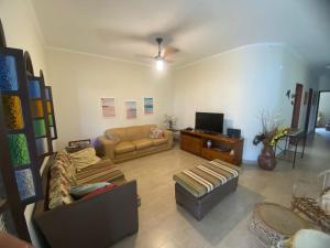 a living room with a couch and a tv at Pousada Allmar in Bertioga