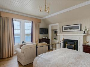 ein Schlafzimmer mit Bett, Stuhl und Kamin in der Unterkunft Ards House in Oban