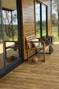 a person sitting on a bench on the porch of a house at Monte da Tojeirinha in Montargil