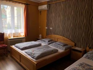two twin beds in a bedroom with a window at Árpád Vendégház in Hajdúszoboszló