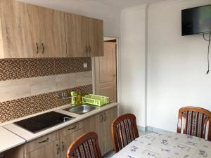 a kitchen with a sink and a table with chairs at Árpád Vendégház in Hajdúszoboszló