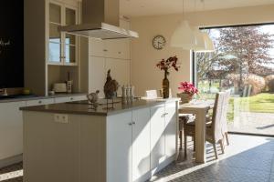 a kitchen with a large island with a dining table at Vakantiewoning Kastijd Kortessem - Haspengouw in Kortessem