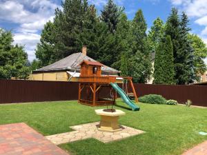 a playground with a slide in a yard at Árpád Vendégház in Hajdúszoboszló