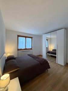 a bedroom with a large bed and a mirror at Ca' de Mario in Sondalo