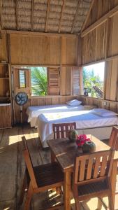 a bedroom with a bed and a table and chairs at Pousada Amor Do Arpoador in Tutóia