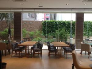 a restaurant with wooden tables and chairs and windows at Unique Santos - Flat 1105 in Santos