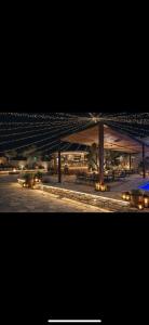 two photographs of a building with benches and lights at Flogeri in Vlorë