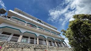 a white building with balconies on top of it at Hotel Himalayan View Kedarnath in Phata