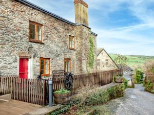 a brick house with a red door and a fence at Tuckenhay, 3 Castle Cottage - Fcm in Ashsprington