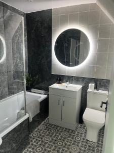 a bathroom with a toilet and a sink and a mirror at 60 Springfield Road in Stornoway +13 photos