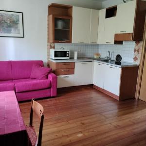 a living room with a purple couch and a kitchen at Agriturismo Praetto in Marcon